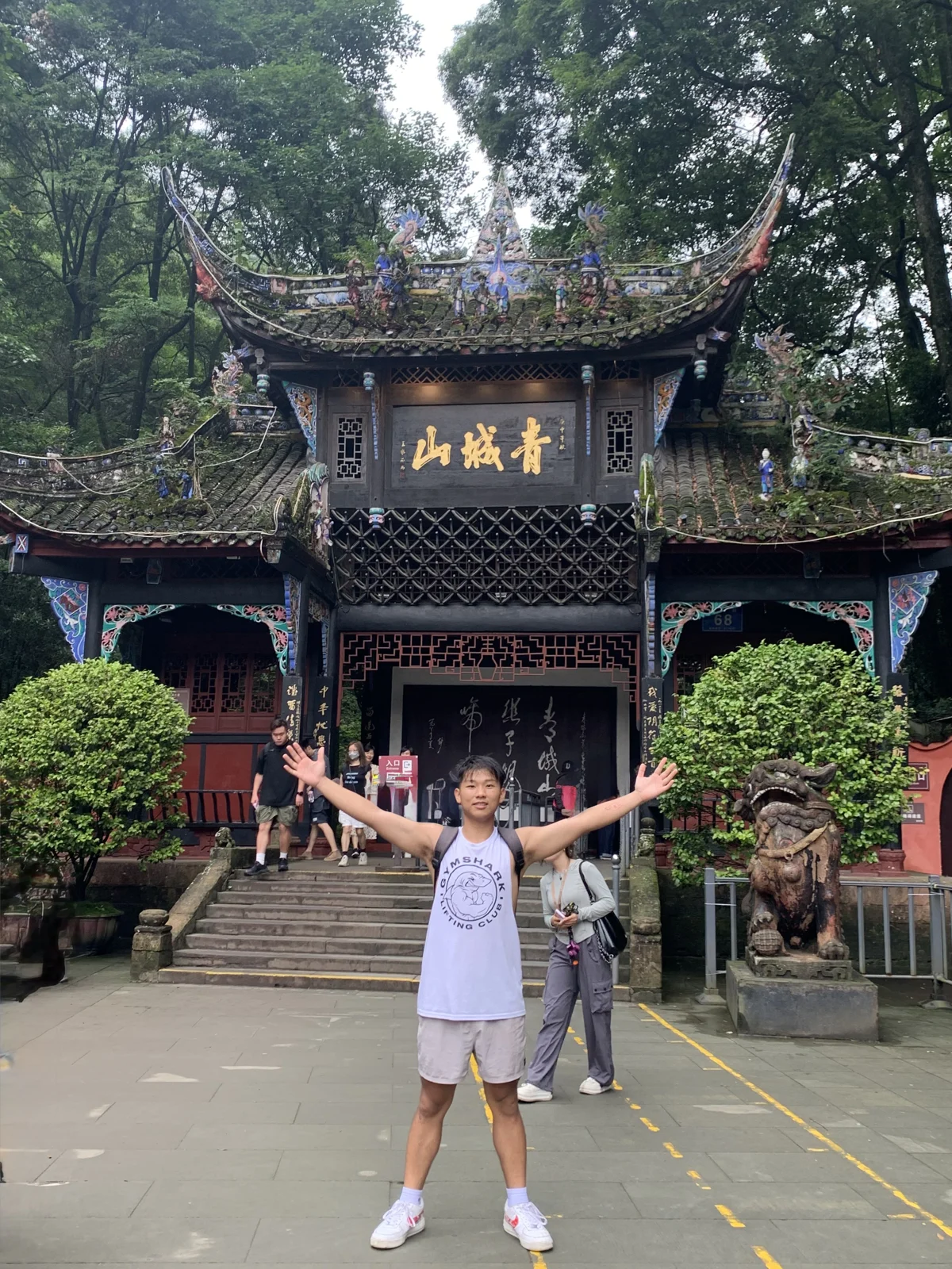 Tony standing in front of a traditional building surrounded by trees